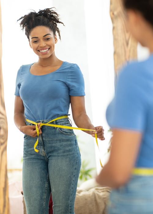 Confident woman looking in the mirror after medical weight loss